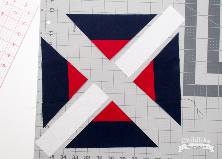 Sew triangle units to 7" x 1.75" strip, align cut edges