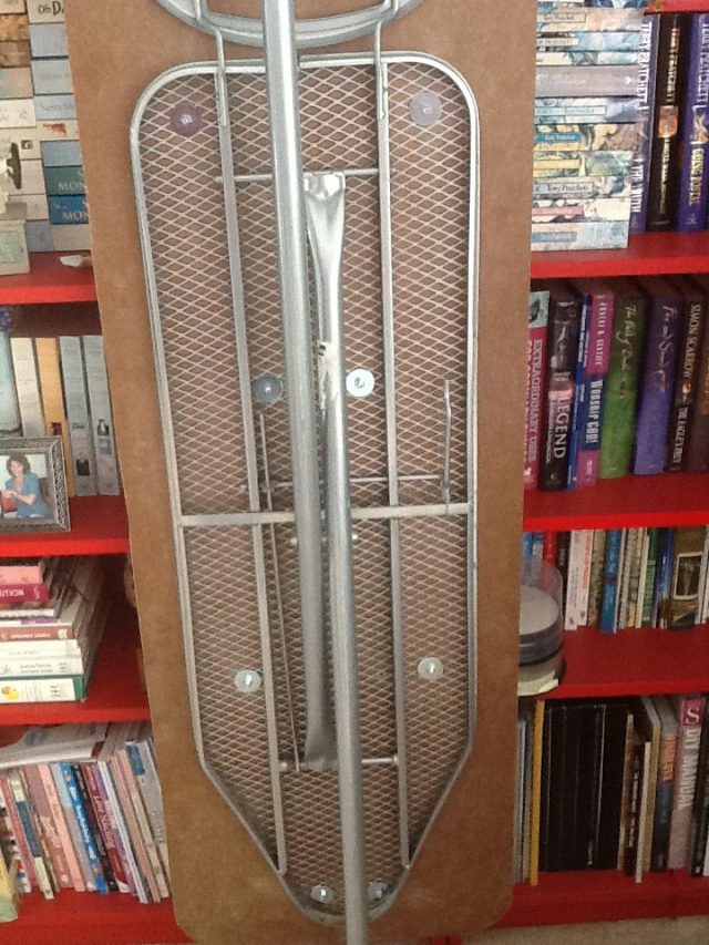 Wood top attached to the ironing board  with washers and screws
